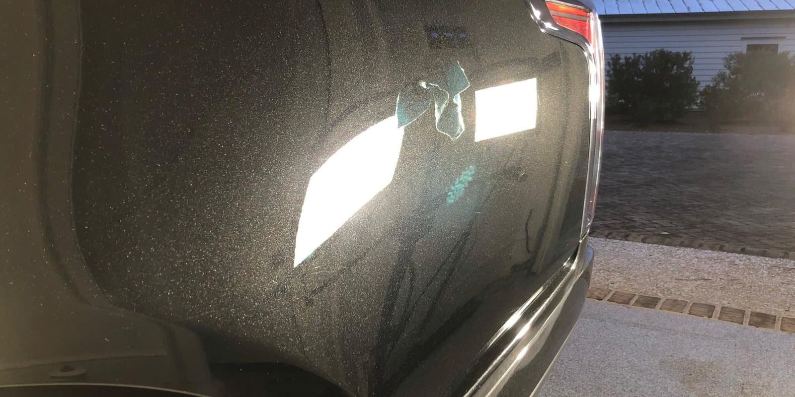 The same rear quarter panel with a clear, swirl-free reflection after paint correction
