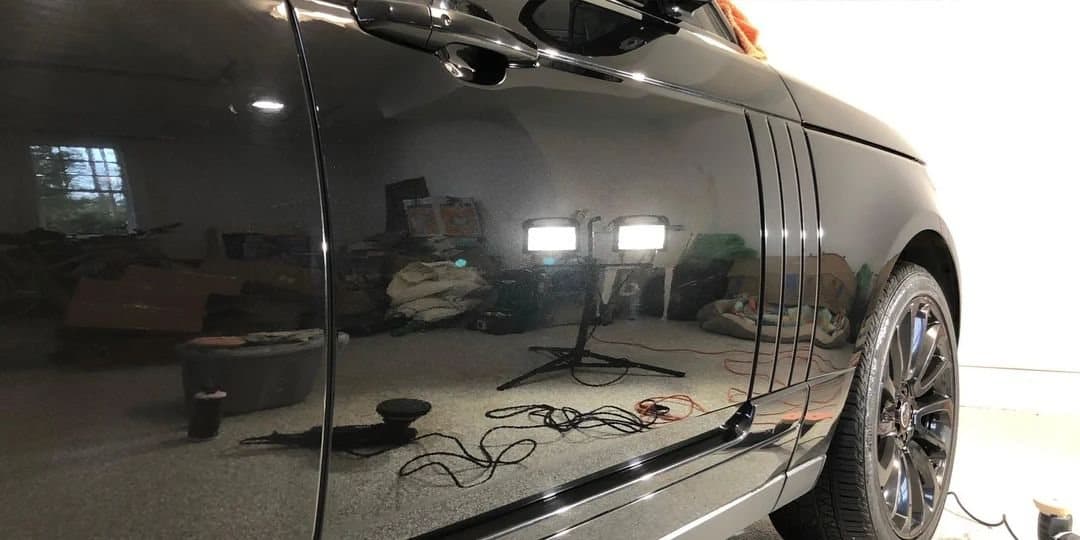The same Range Rover door panel with a sharp, clear reflection after paint correction